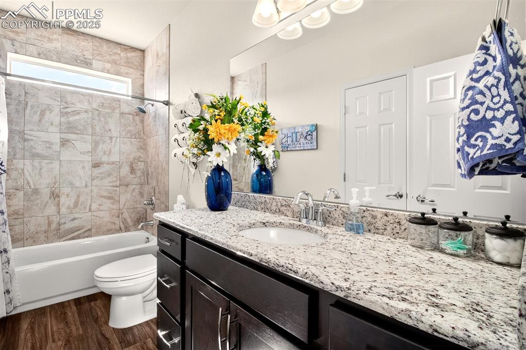 Image 26 of 43: Bathroom featuring shower / bath combination with curtain, vanity, and dark