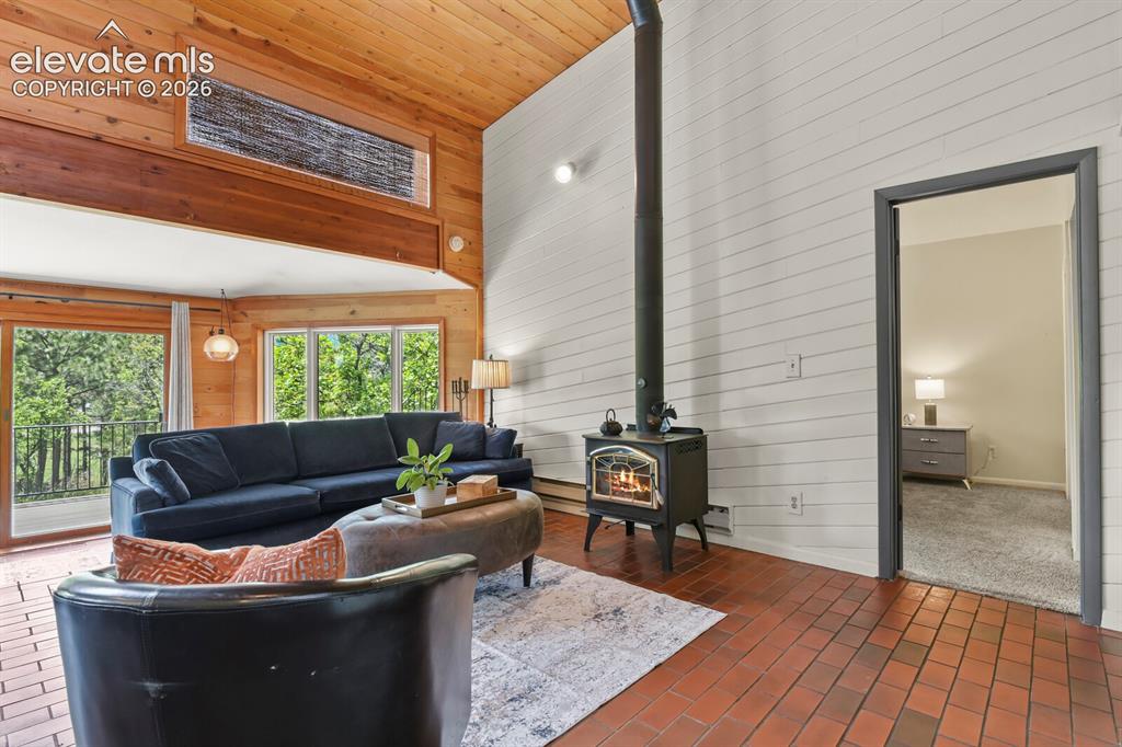 Image 16 of 49: Warm and inviting living room with soaring ceilings and abundant natural li