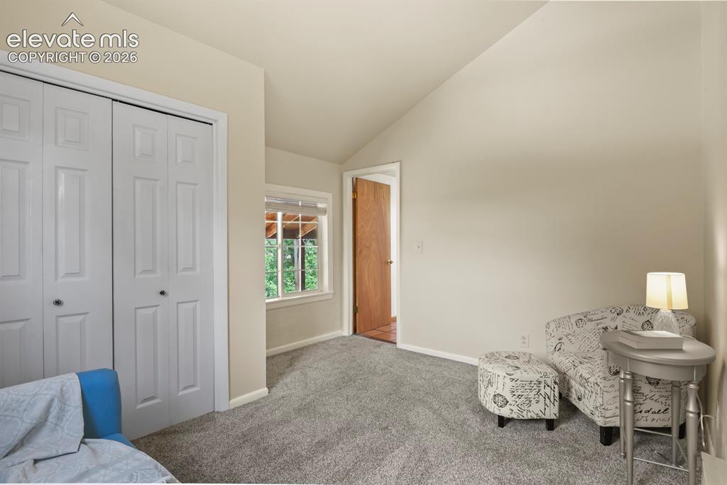 Image 27 of 49: Inviting upper-level bedroom with woodland views.