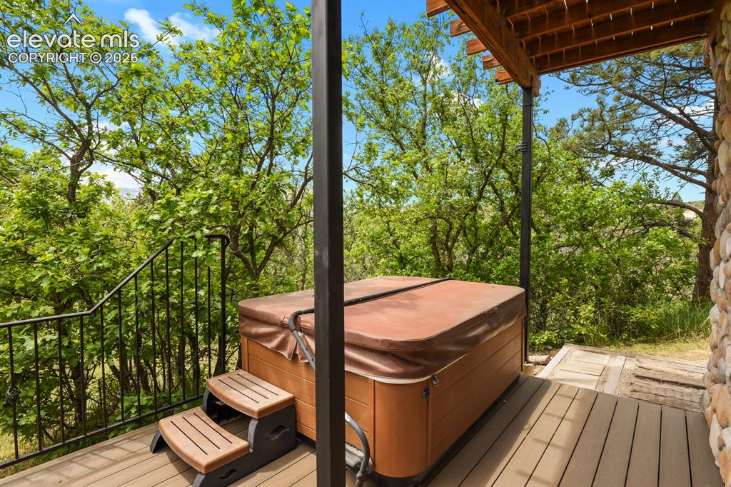 Image 36 of 49: Hot tub retreat nestled among the trees for year-round enjoyment.