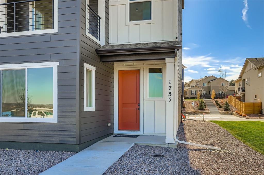 Image 2 of 13: Doorway to property featuring board and batten siding, a shingled roof, and