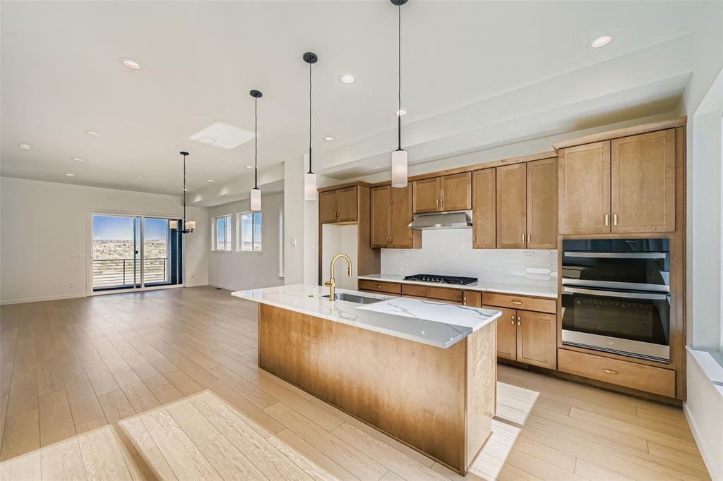 Image 6 of 13: Kitchen with decorative light fixtures, appliances with stainless steel fin