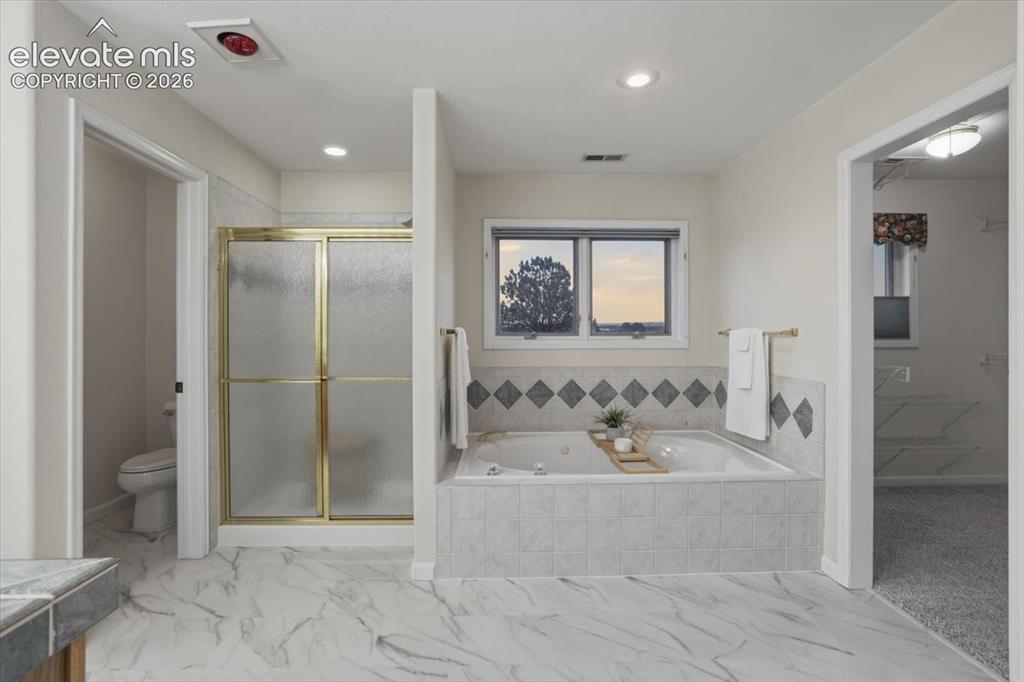 Image 14 of 48: Tiled flooring extending throughout, built-in soaking tub with tiled surrou