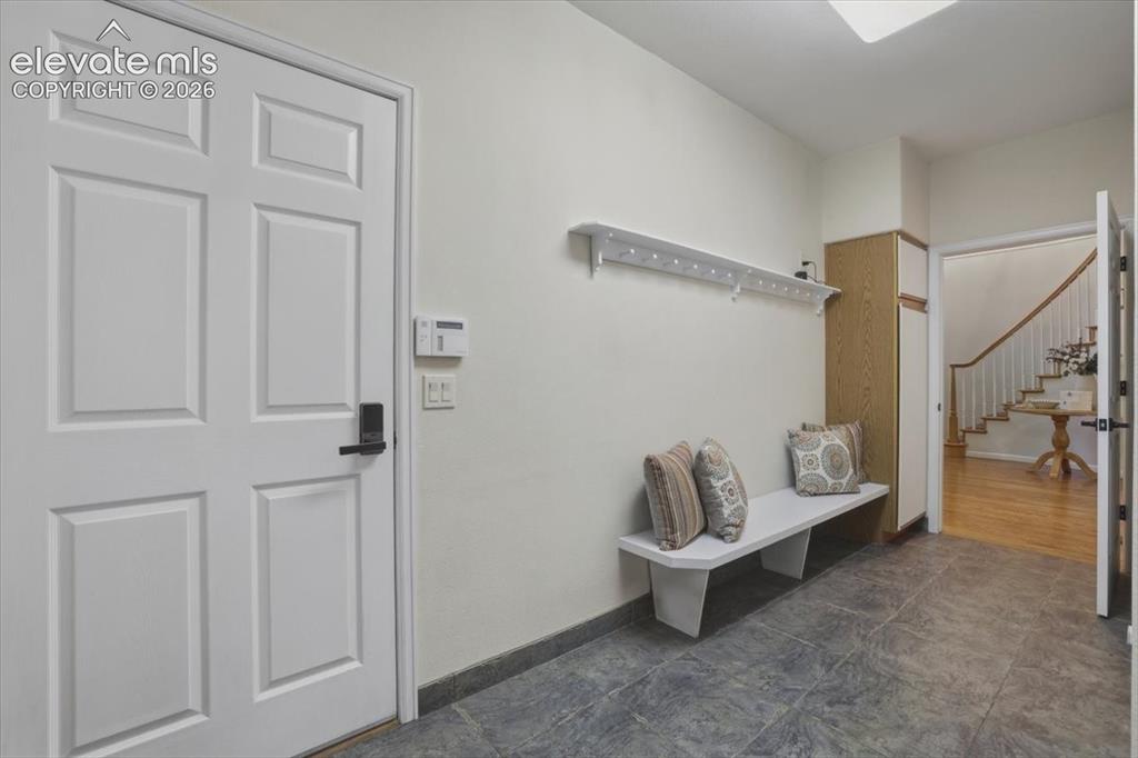 Image 18 of 48: Six-panel interior door with matte black hardware, tiled flooring, wood-fin