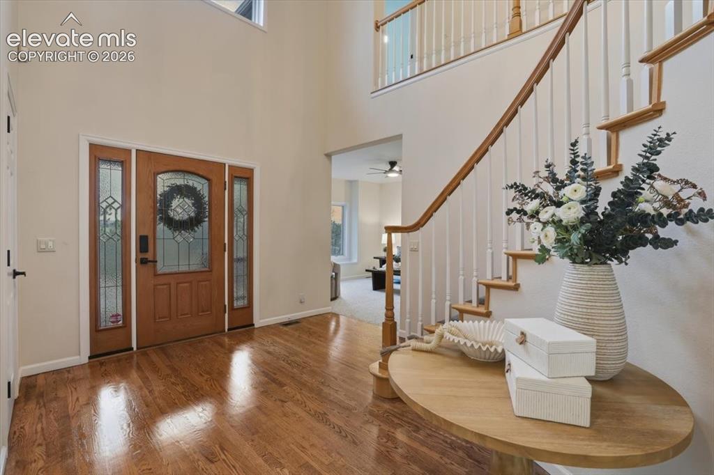Image 23 of 48: Hardwood flooring with a decorative wood entry door and sidelights, featuri