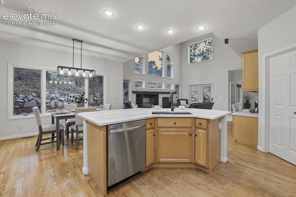 Image 29 of 48: Kitchen island with integrated sink and stainless steel dishwasher