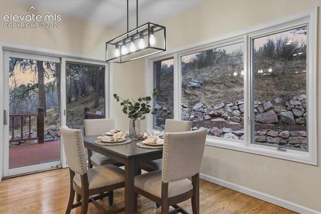 Image 30 of 48: Dining area featuring wood flooring, a contemporary linear chandelier, mult