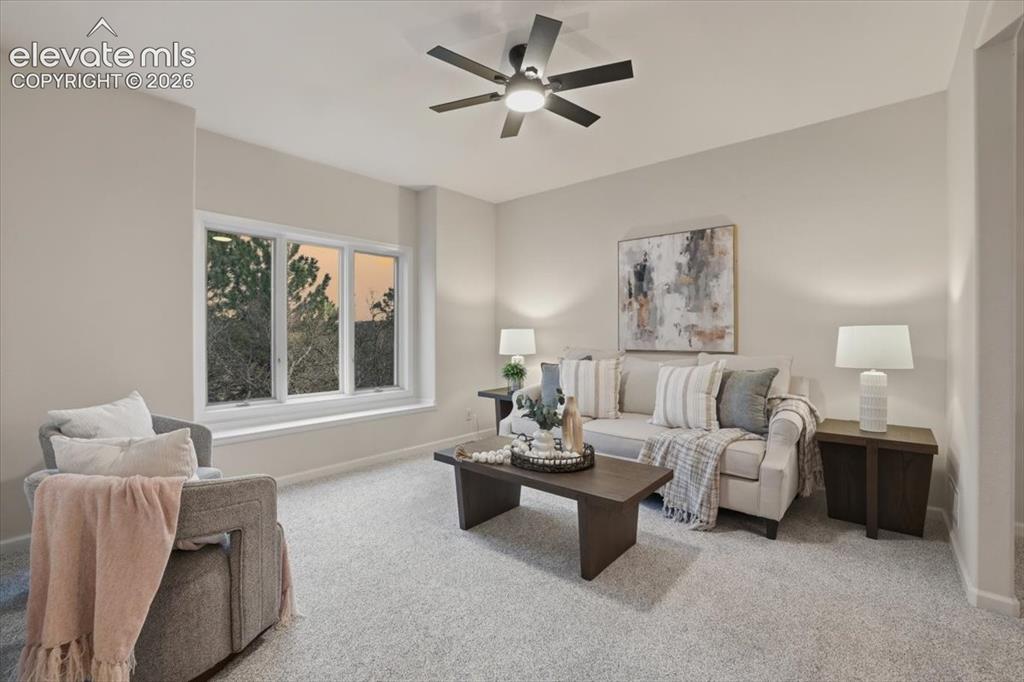 Image 33 of 48: Expansive window with a wide sill, ceiling fan, and carpeted flooring