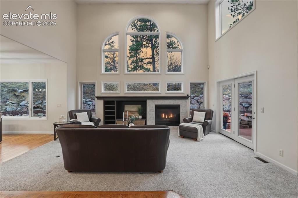 Image 41 of 48: Vaulted ceiling with arched windows, stone-clad fireplace with mantel, buil