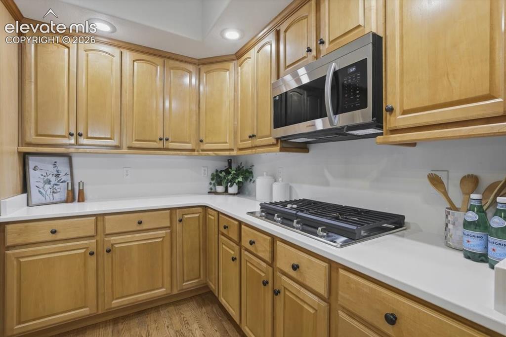 Image 43 of 48: Wood cabinetry, white quartz countertops, built-in stainless steel microwav
