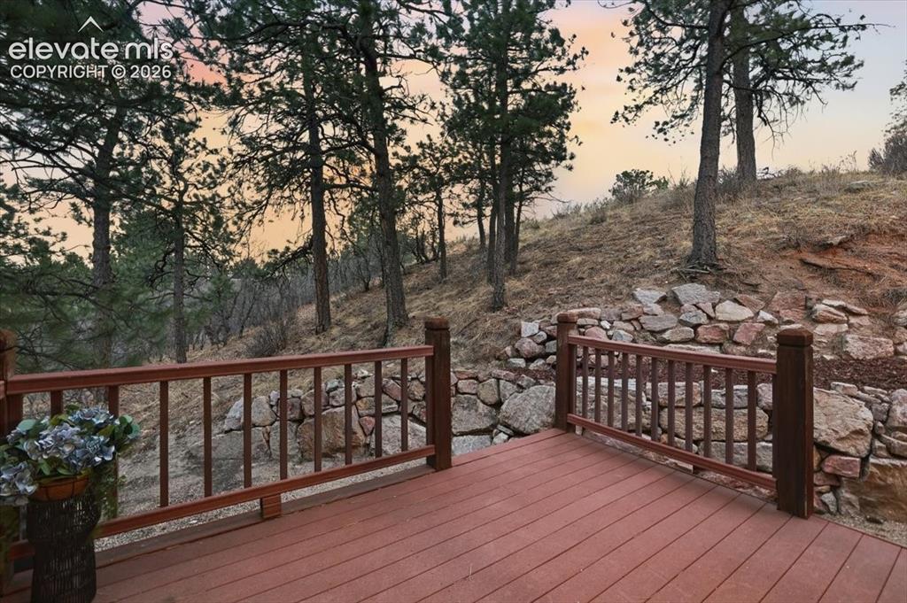 Image 9 of 48: Expansive outdoor decking with wood-finish railing, set against a natural, 