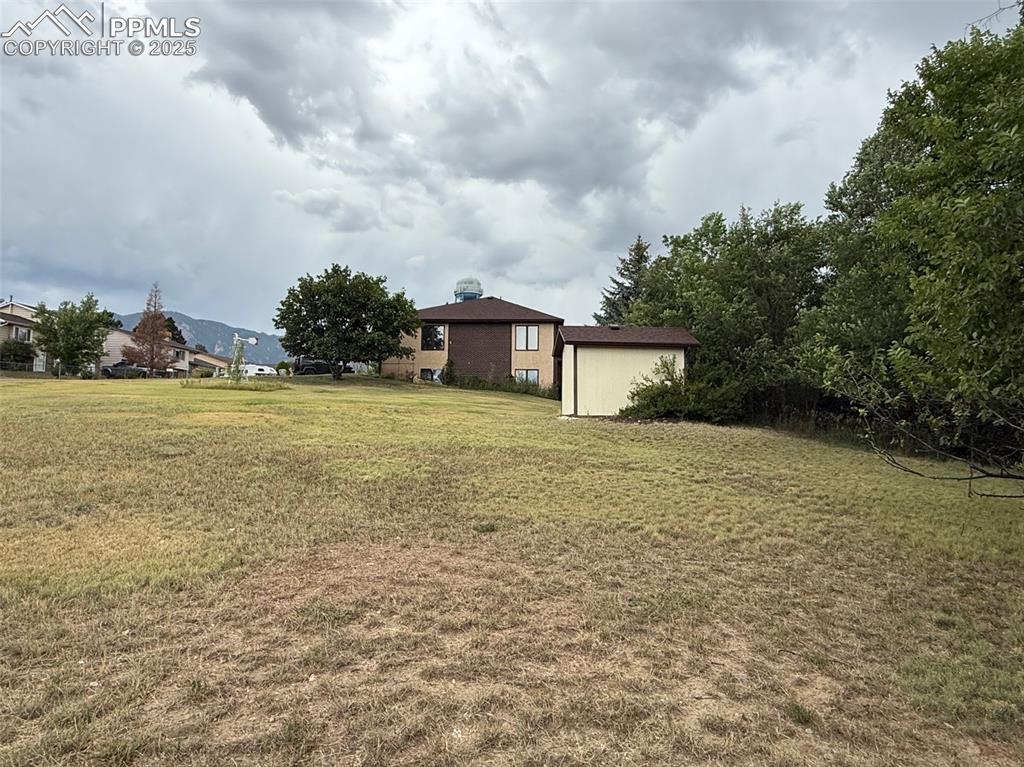 Caption: View of grassy yard with a storage shed