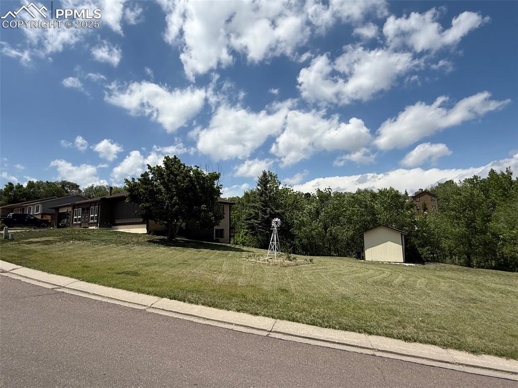 Image 3 of 3: View of front of property with a shed and a front lawn