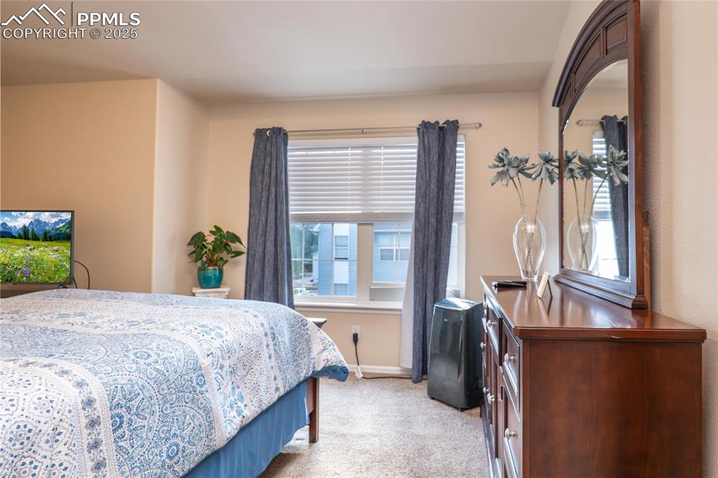 Image 13 of 25: Upper primary bedroom has carpet and backs to open space.