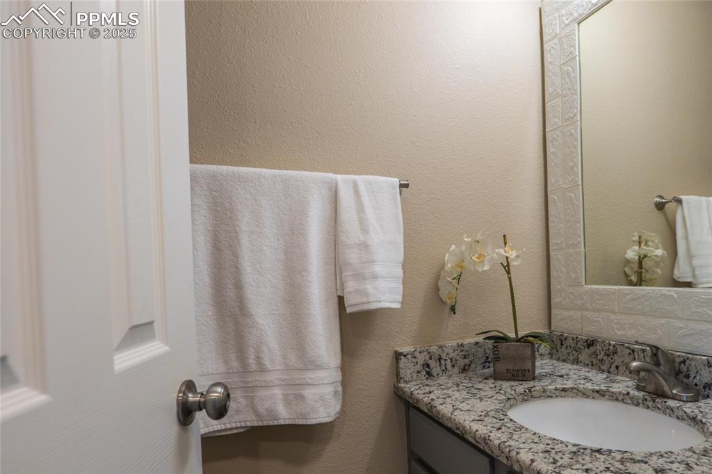 Image 8 of 25: Main level 1/2 bath to include granite countertop and LVP flooring.