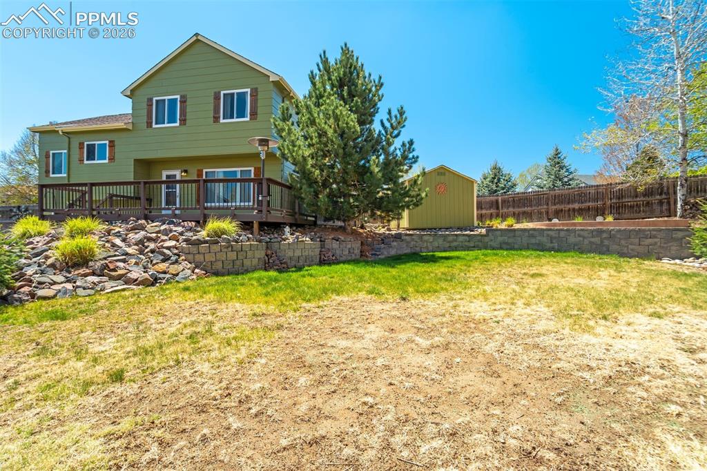 Image 38 of 46: Ideal yard for hosting, gardening, storing, and playing. 