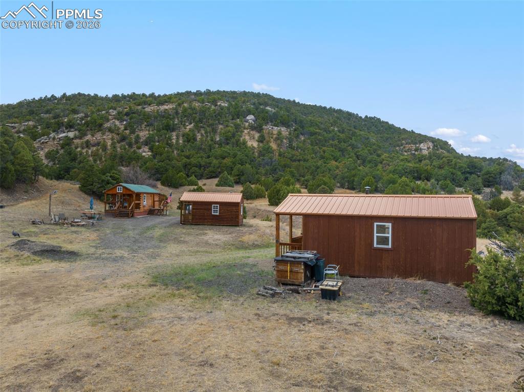 Image 29 of 50: Buildings from left to right...log cabin, bunkhouse cabin, and saloon cabin