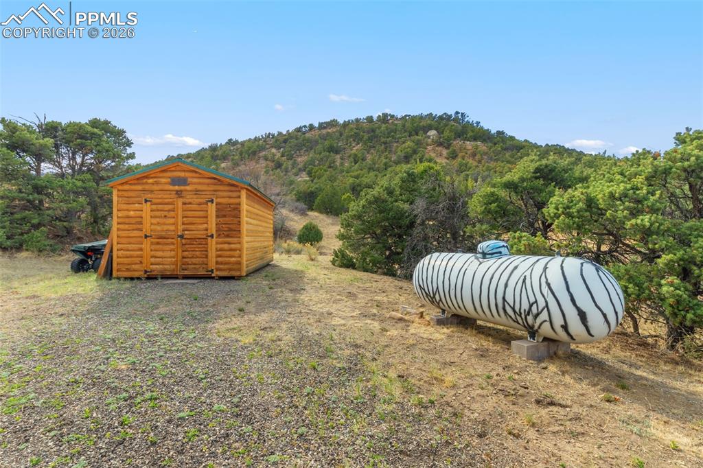 Image 42 of 50: Storage shed and 500 gallon propane tank convey.