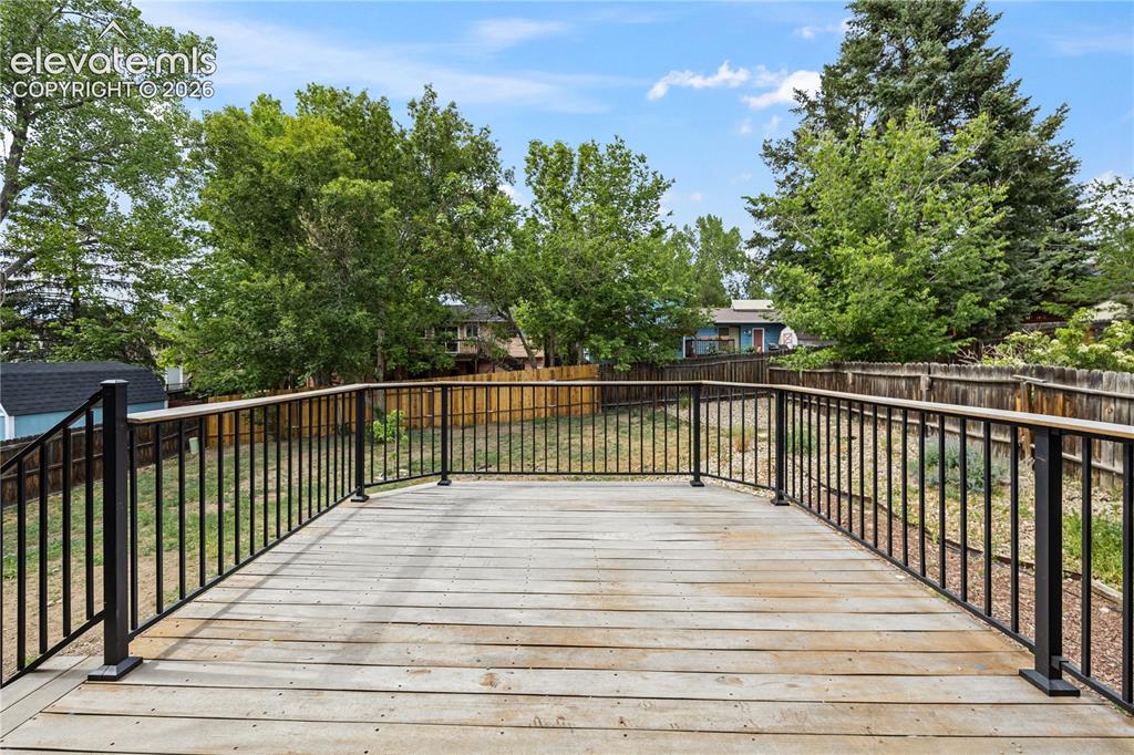 Image 28 of 32: spacious deck overlooking the backyard with mountain views to the West