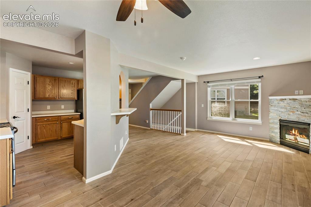 Image 15 of 48: New floors and stacked stone on fireplace. Walks out to back deck.