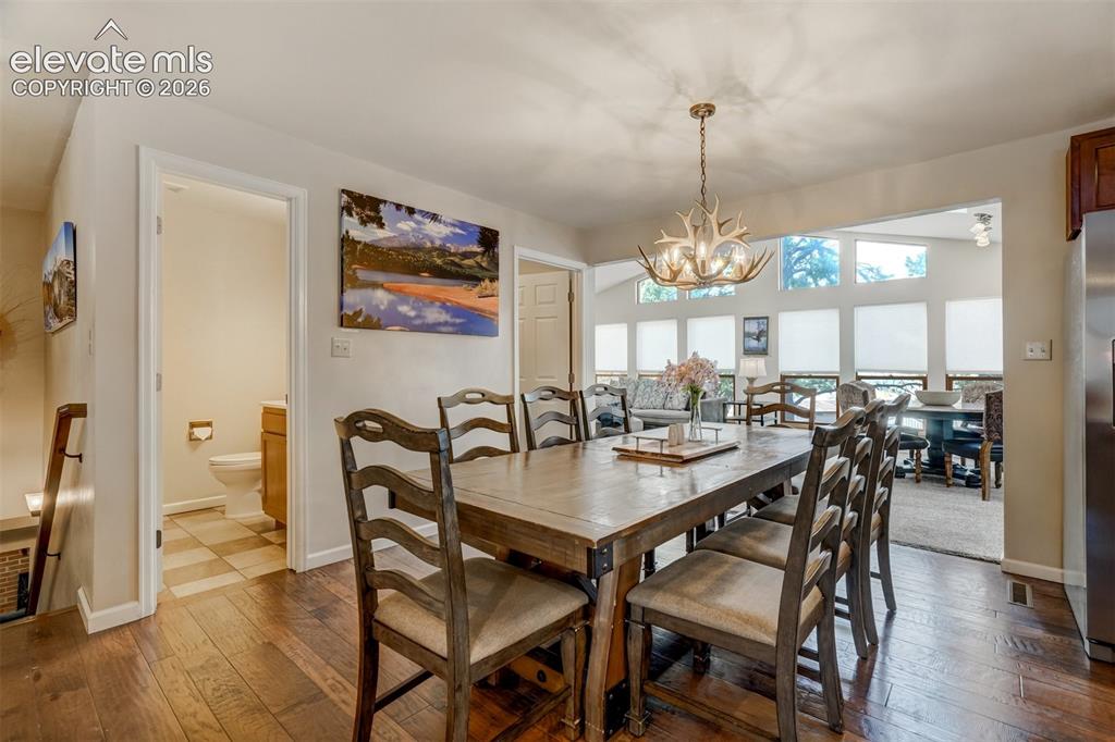 Image 15 of 50: Open concept dining space featuring wood-finish flooring, a unique antler-s