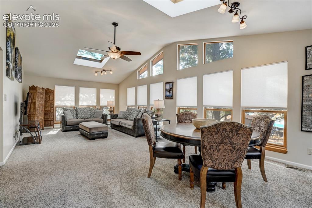 Image 16 of 50: Vaulted ceiling with skylights and ceiling fan