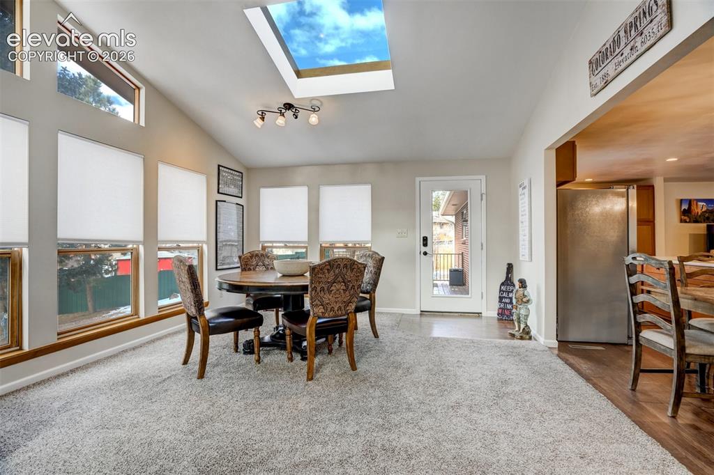 Image 21 of 50: Vaulted ceiling with skylight and track lighting