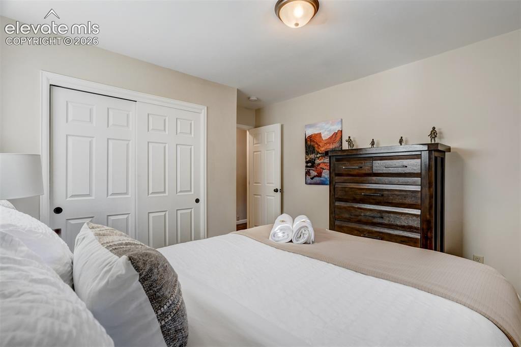 Image 26 of 50: Six-panel bifold closet doors with black hardware