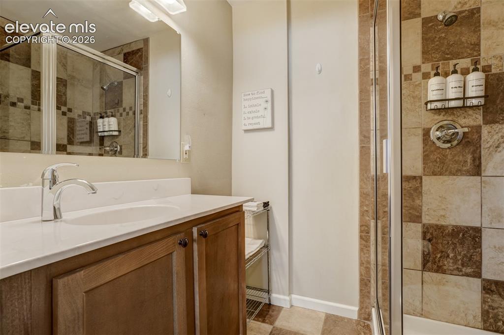 Image 29 of 50: Glass-enclosed shower with tiled walls and chrome fixtures