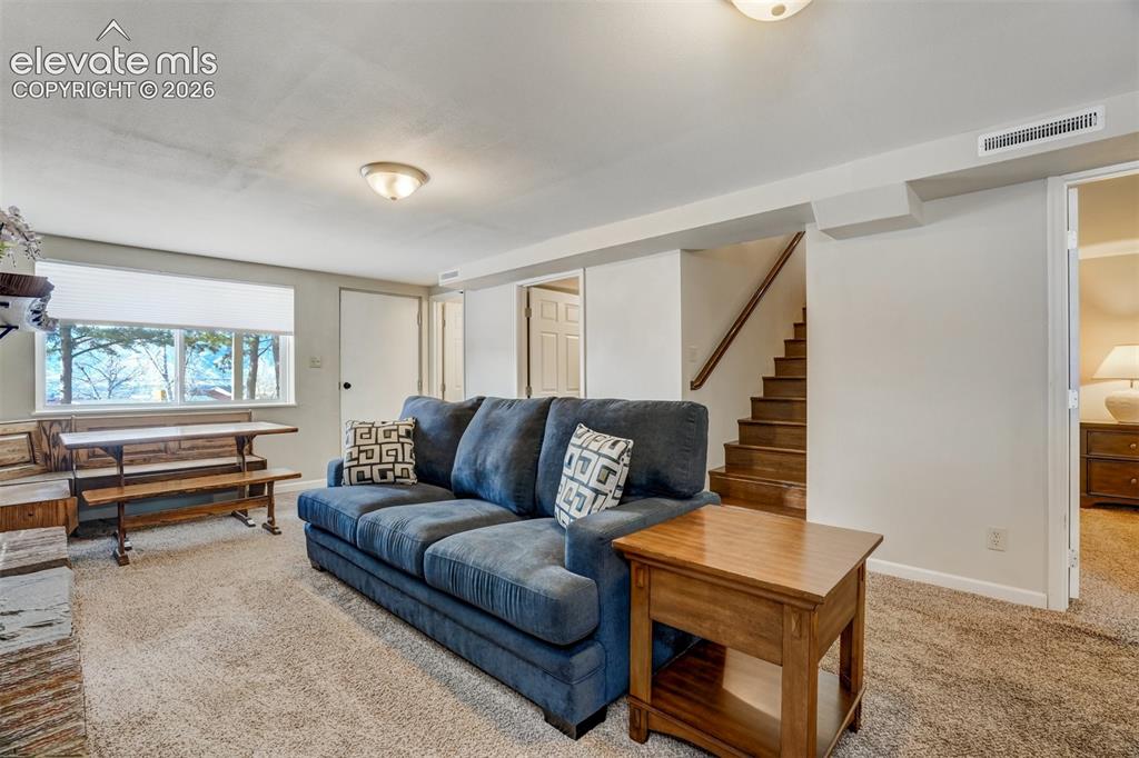 Image 36 of 50: Carpeted flooring throughout, recessed window with blinds, wood-finish stai