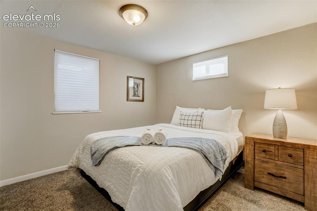 Image 38 of 50: Recessed ceiling light fixture, two windows with blinds, and textured wall 