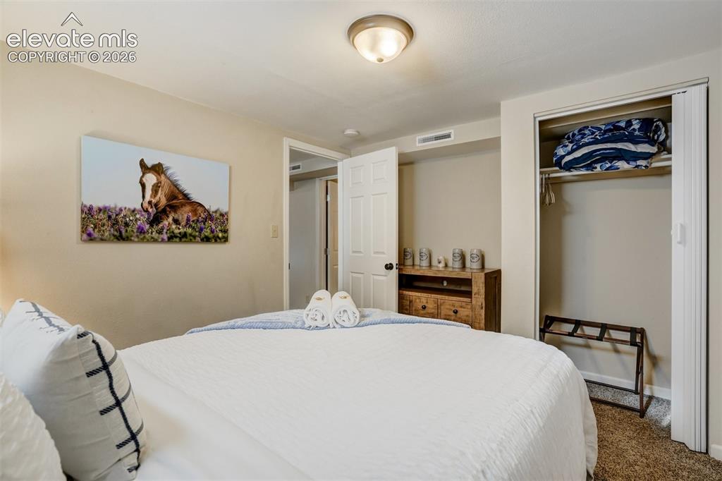 Image 39 of 50: Carpeted flooring, bi-fold closet doors, built-in closet rod, and an attach