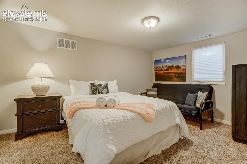 Image 40 of 50: Neutral-toned carpeting, single window with privacy blind, built-in ceiling