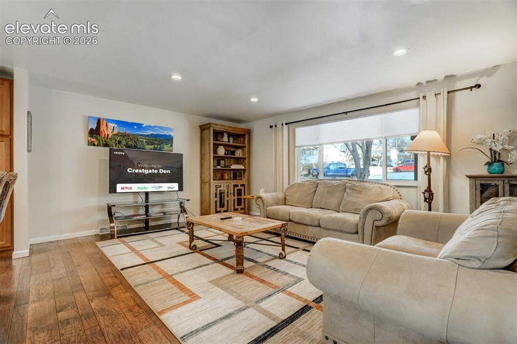 Image 5 of 50: Recessed ceiling lighting, wood-finish flooring, built-in shelving unit, an