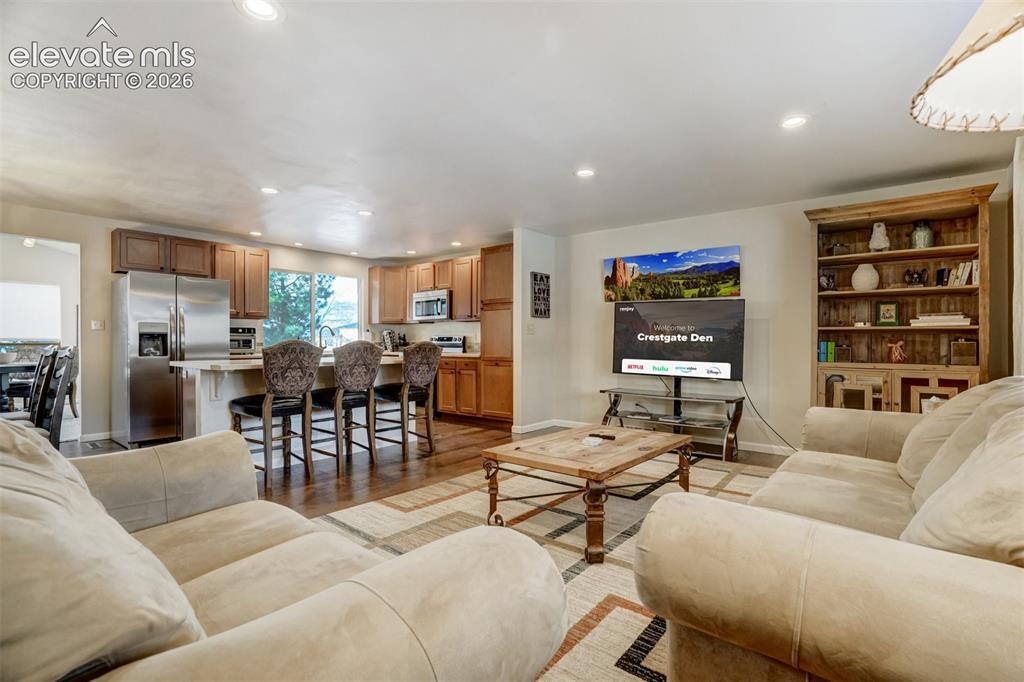 Image 6 of 50: Open-concept living space featuring wood-finish flooring, recessed lighting