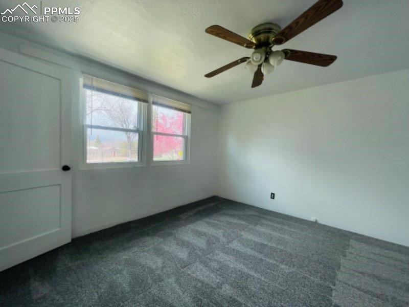 Image 14 of 22: Spare room with dark colored carpet