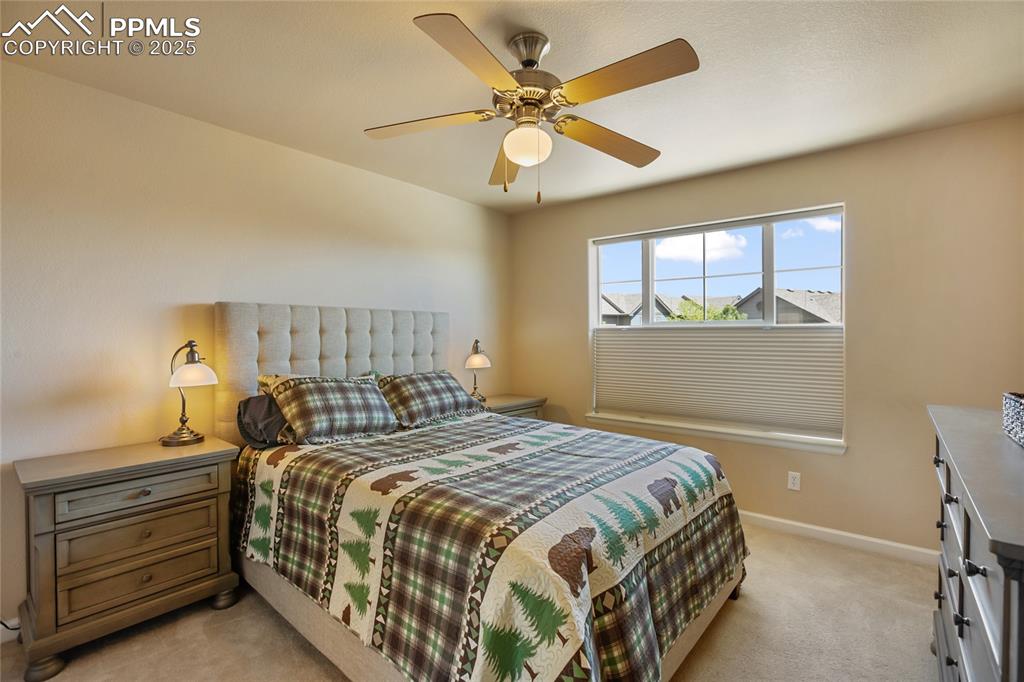 Image 22 of 36: Bedroom featuring a ceiling fan, baseboards, and light colored carpet