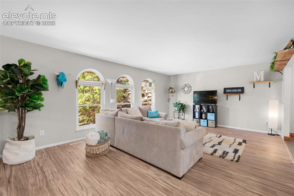 Image 5 of 44: Stunning living room with attractive 3 arched windows that overlook the nat