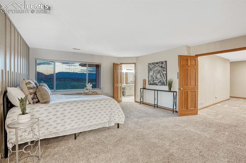 Image 19 of 43: The primary bedroom has been refreshed with new carpet & decorative wainsco