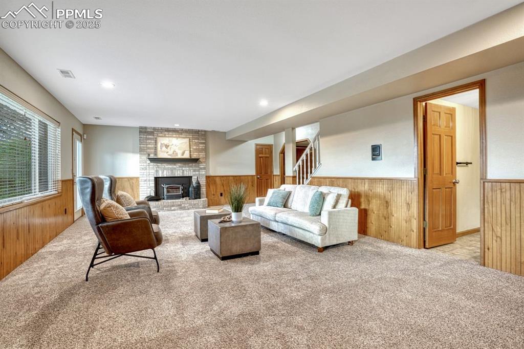 Image 32 of 43: Cozy great room with warm wood wainscoting, plush carpet and plenty of room