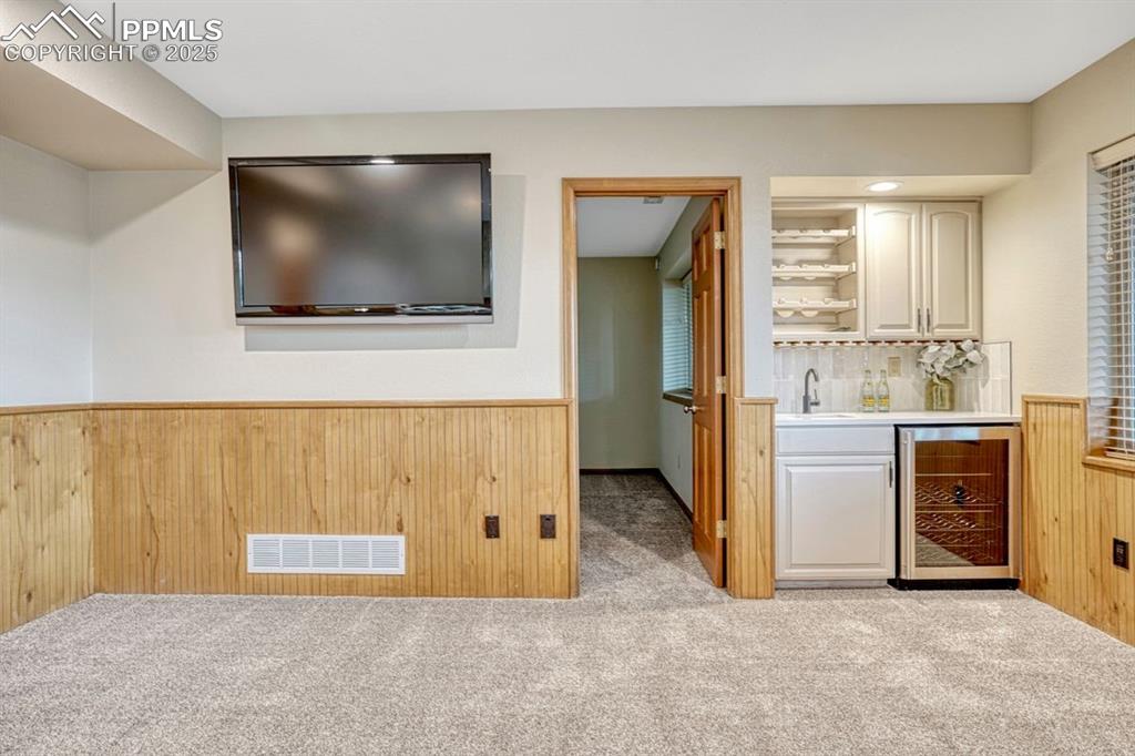 Image 33 of 43: Convenient wet bar with wine cooler and storage tucked into a corner of the