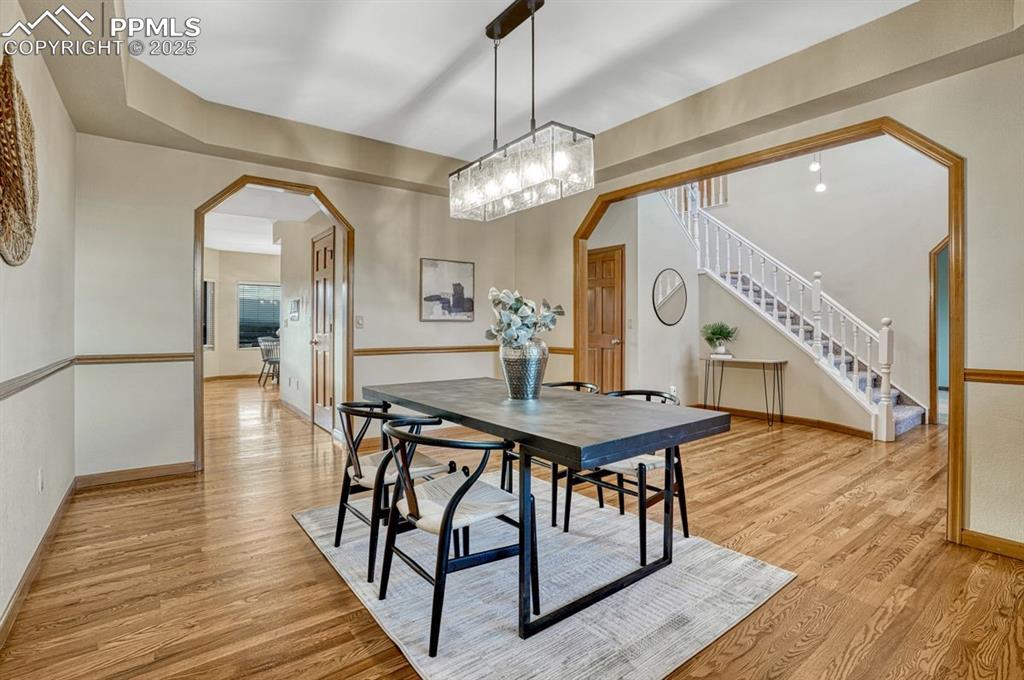 Image 9 of 43: Spacious dining room features a tray ceiling, gleaming hardwood floors, and