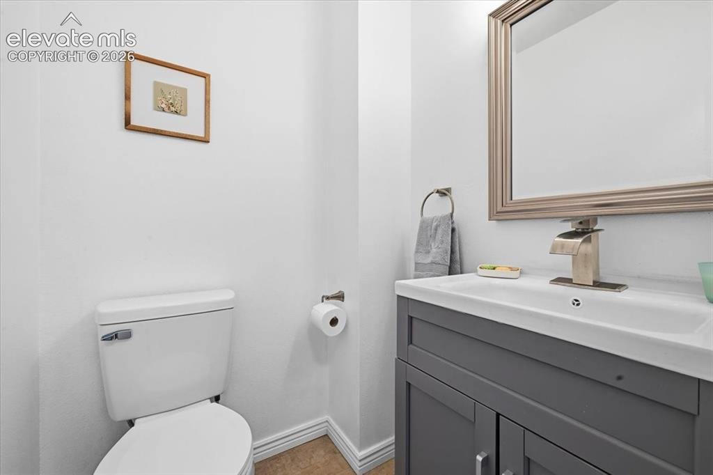Image 13 of 27: Vanity with integrated sink, brushed nickel faucet, framed mirror, and toil