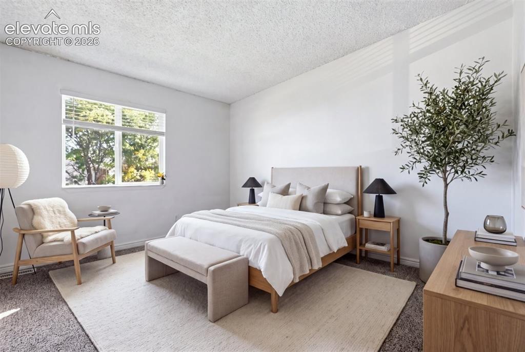 Image 19 of 27: Carpeted room with a large window featuring blinds