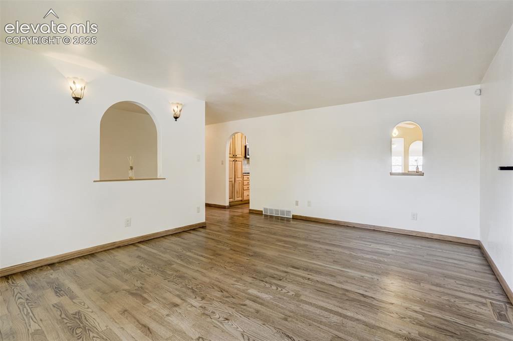 Image 11 of 50: Natural Oak Wood Floors flow from the spacious living room to the lovely ki