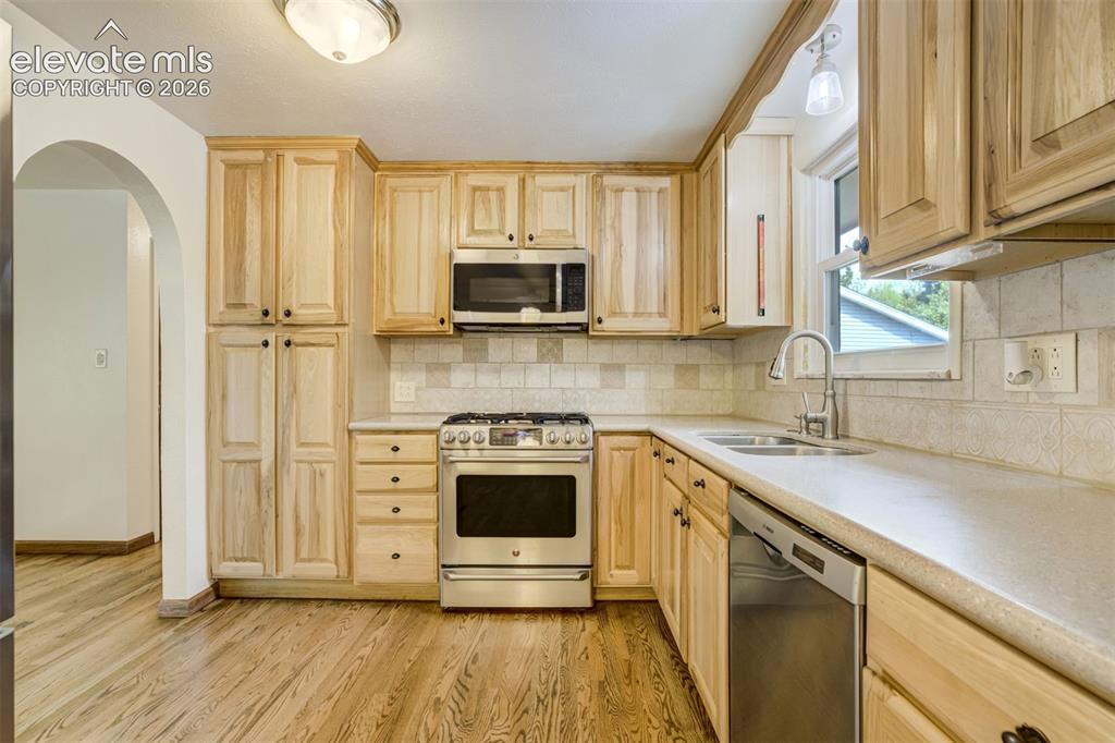 Image 13 of 50: Tastefully done! Hickory Cabinetry, with Stainless Steel Appliances, Backs
