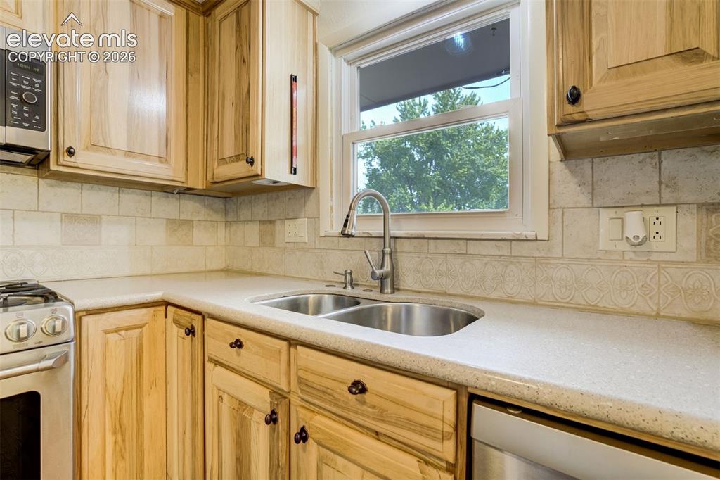 Image 15 of 50: Corion counter tops with undermount sink, Window above the sink is a PLUS