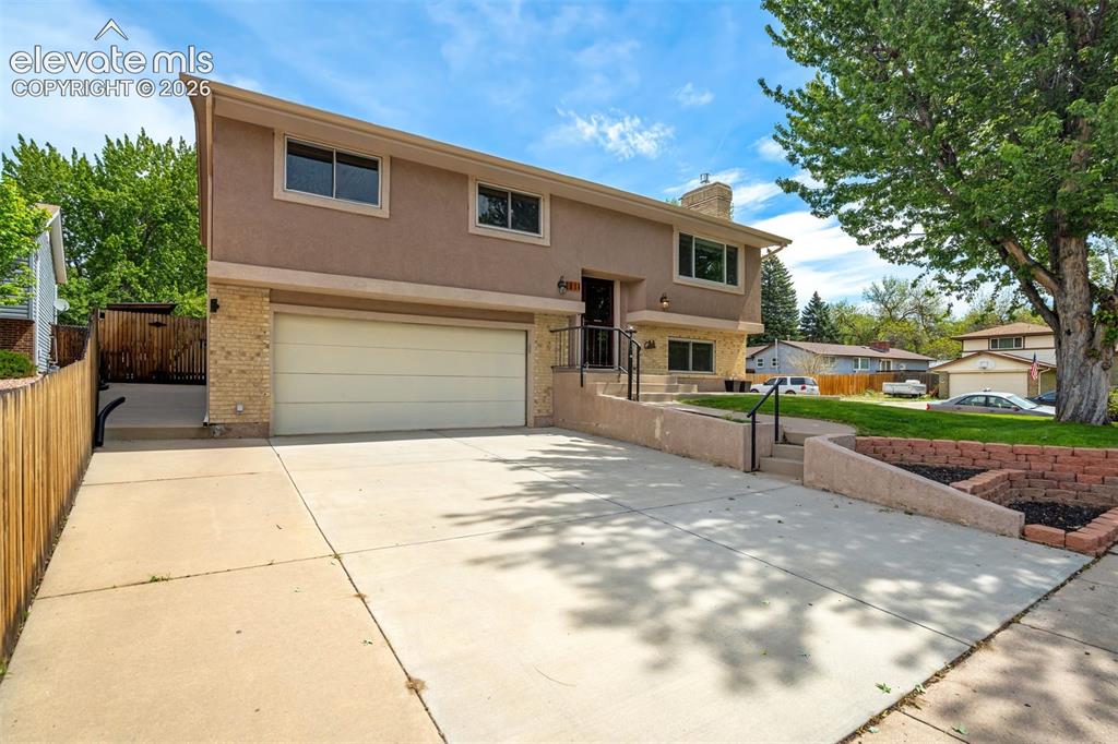 Image 5 of 50: Oversized concrete driveway with a concrete sidewalk to the back fenced in
