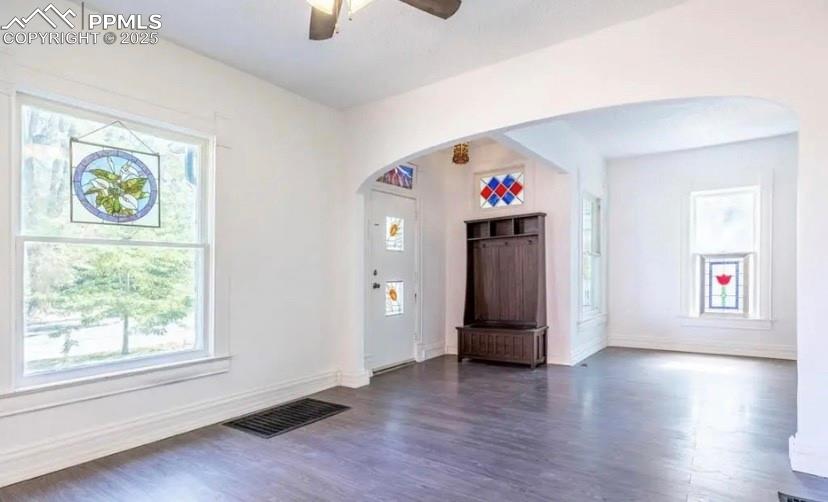 Image 2 of 9: Entryway with arched walkways, healthy amount of natural light, dark wood f