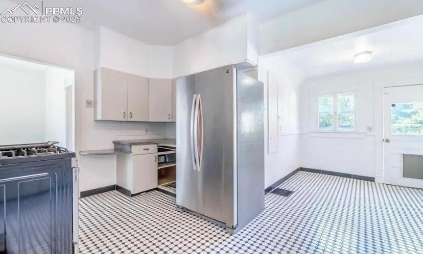 Image 3 of 9: Kitchen with stainless steel appliances and light countertops
